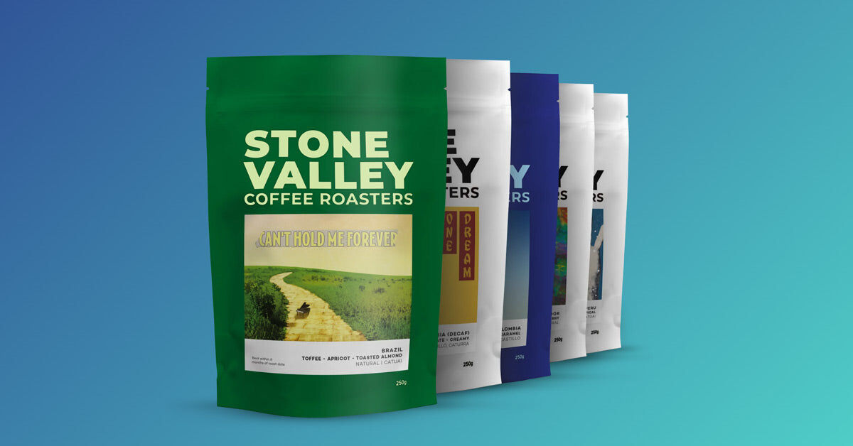 Stone Valley 250g coffee bags in a row, the green Brazil bag at the front